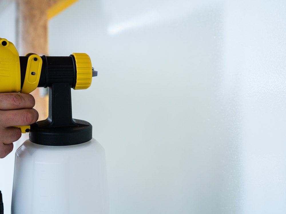 Airless-Pistole lackiert eine Tür mit feinem Spritzbild